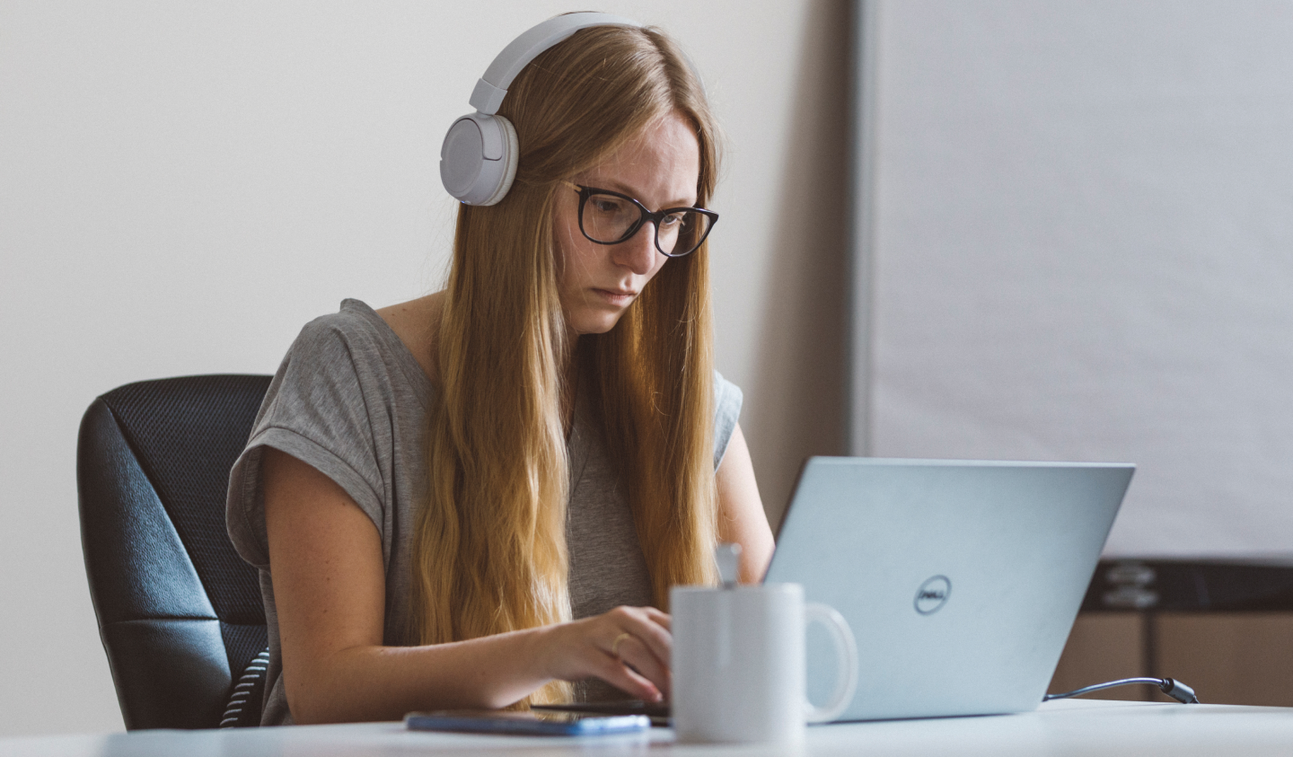 Woman with headset working on a laptop