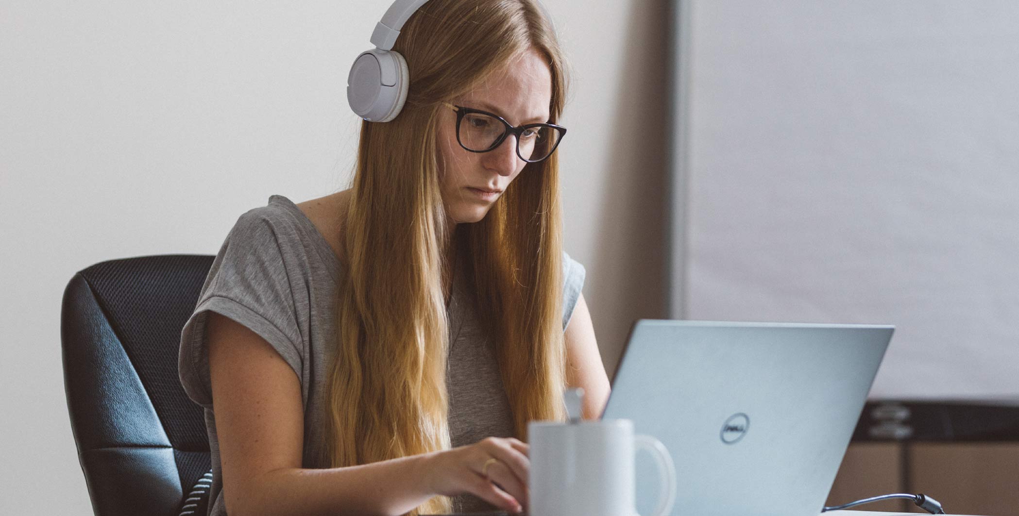 Woman with headset working on a laptop
