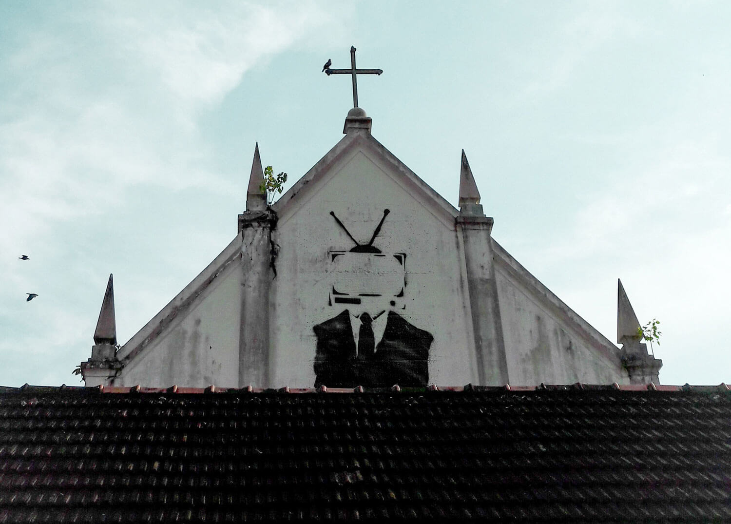 A photo illustration of a conspiracy-looking image graffitied onto the side of a church building.