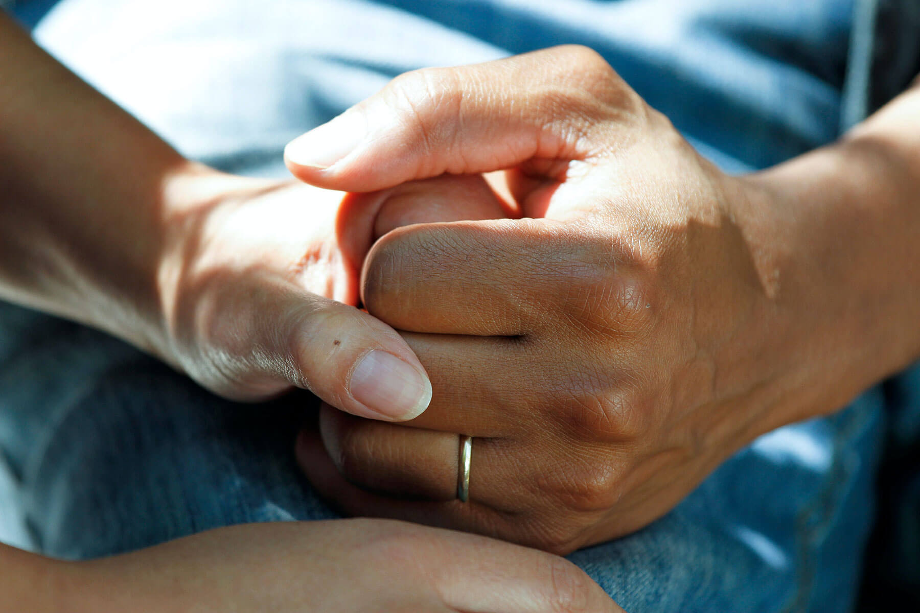 A person comforts someone by holding their hands.
