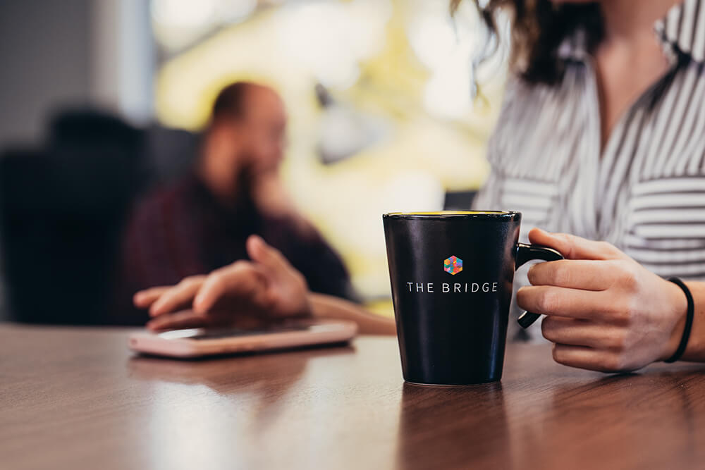 The Bridge puts dedicated desks and single-day visitors in the same room. The vibe is calm and casual.