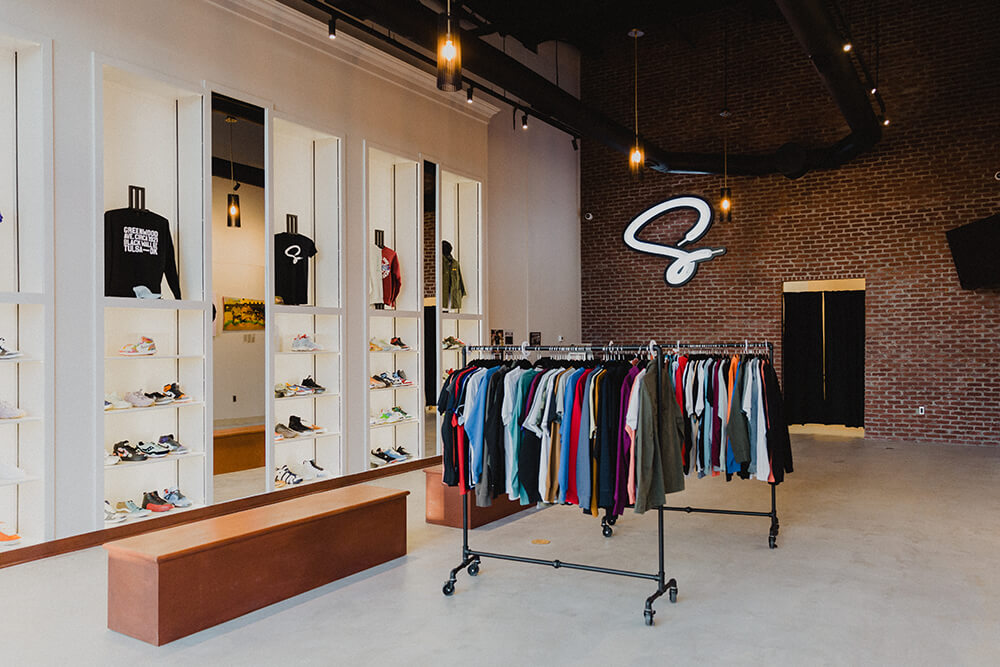 Venita Cooper proudly displays an inventory of some of the coolest sneaker designs ever made on a sleek shelf system on one side of the shop and local art gallery currently featuring art from the Black Moon Collective on the opposite wall. (Photo: Sarah Eliza Roberts)