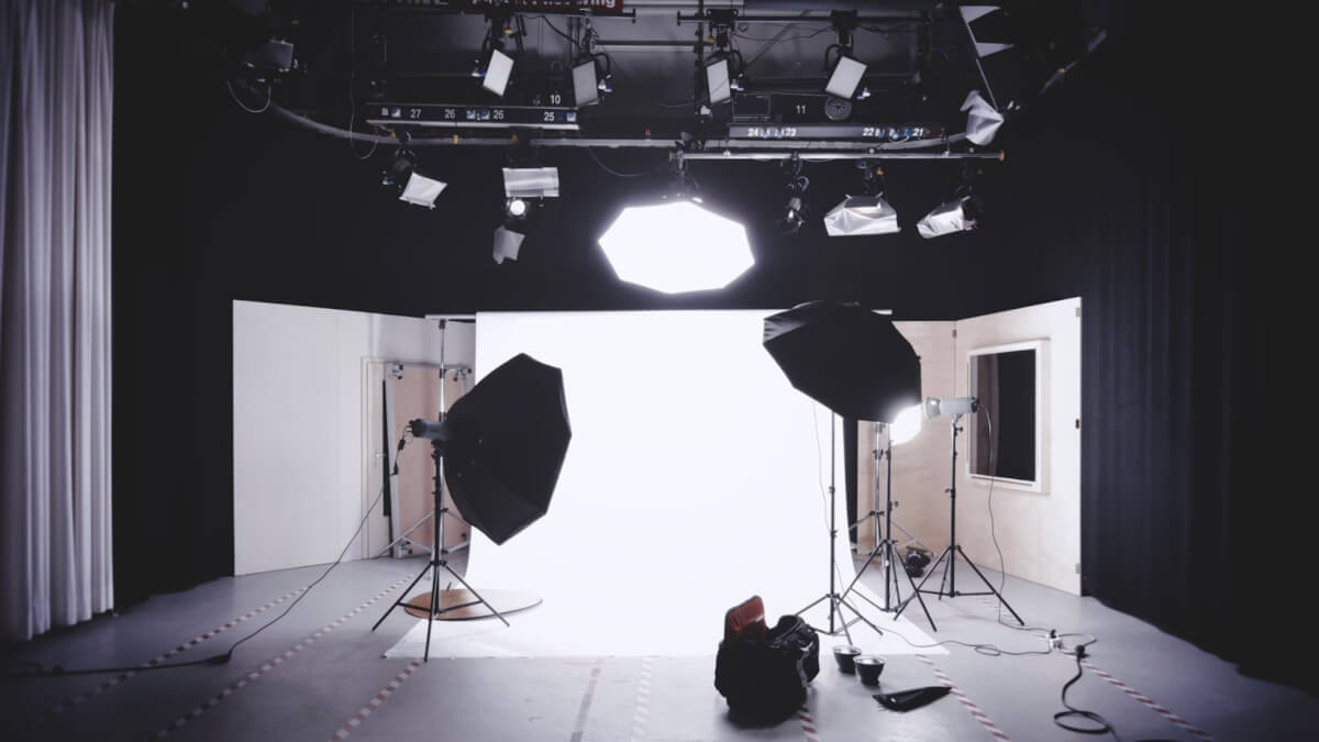 this image shows a dark photography setup illuminated by lights focusing on a white backdrop
