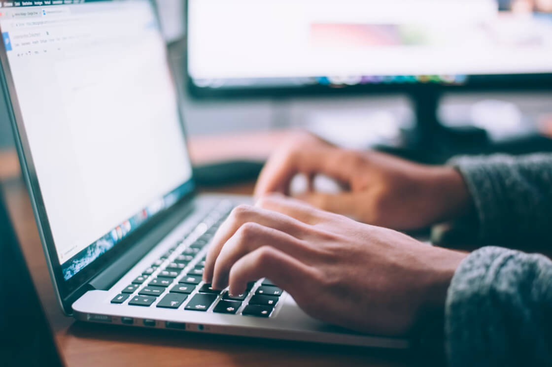 a person typing on his laptop