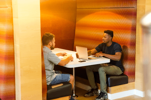 two men having a conversation while working