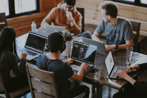five people coworking on a big table