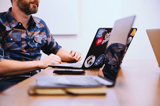 A man working on a laptop with stickers
