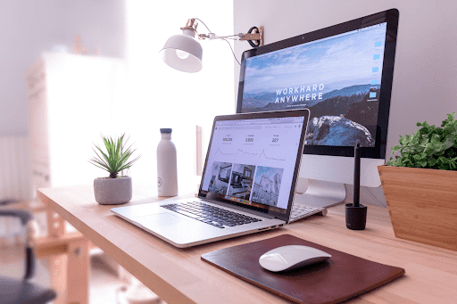 a laptop and computer monitor that says 'work hard anywhere'
