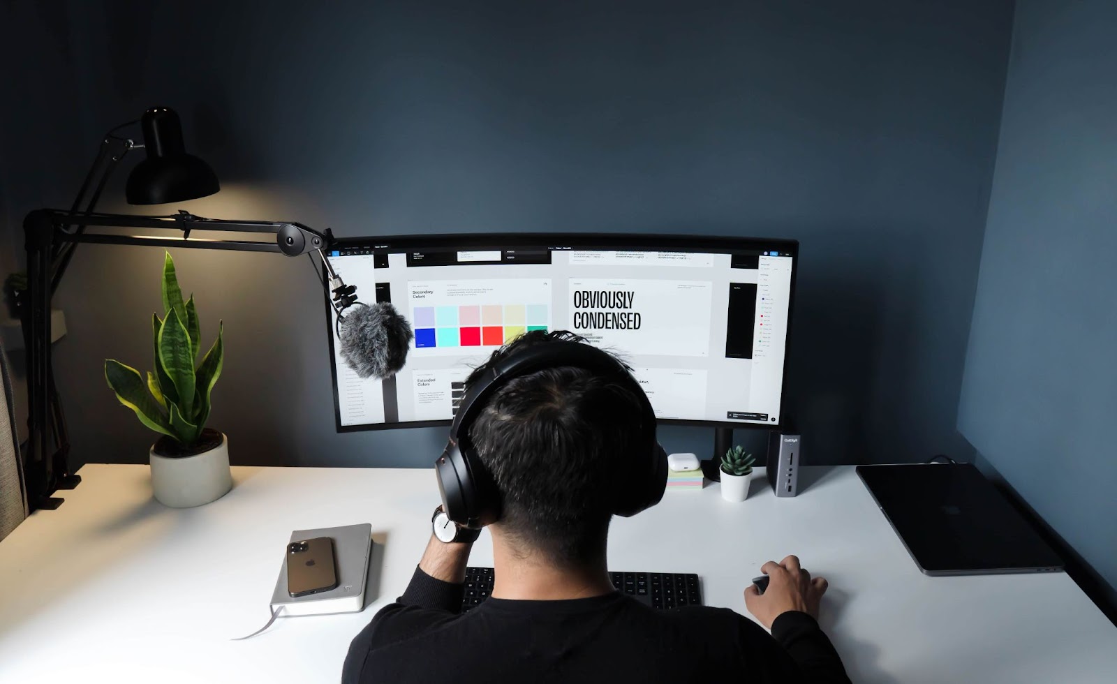 a man wearing his headphone and designing on his computer