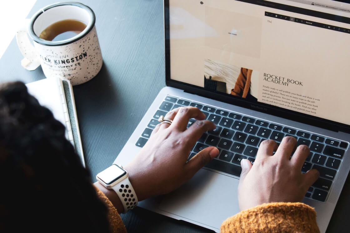 woman working on her desk while having tea