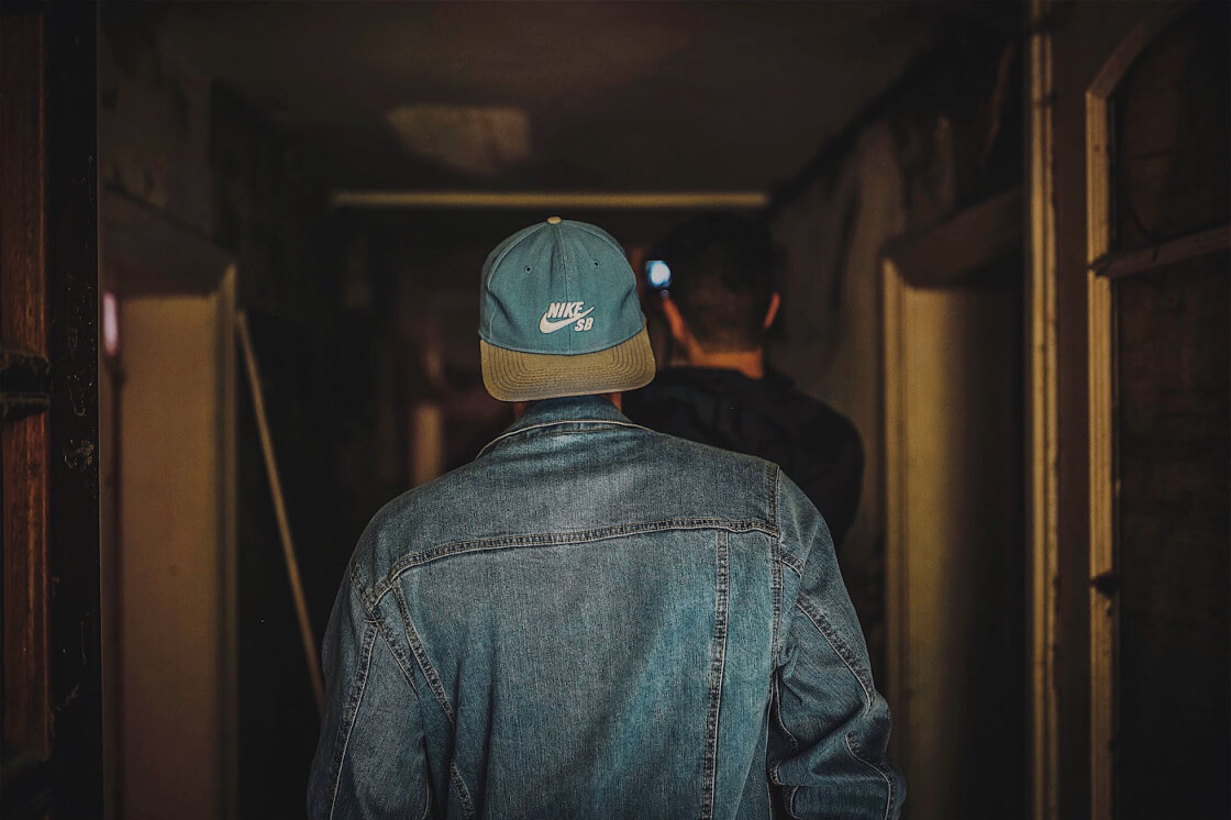two men walking in a dim hallway