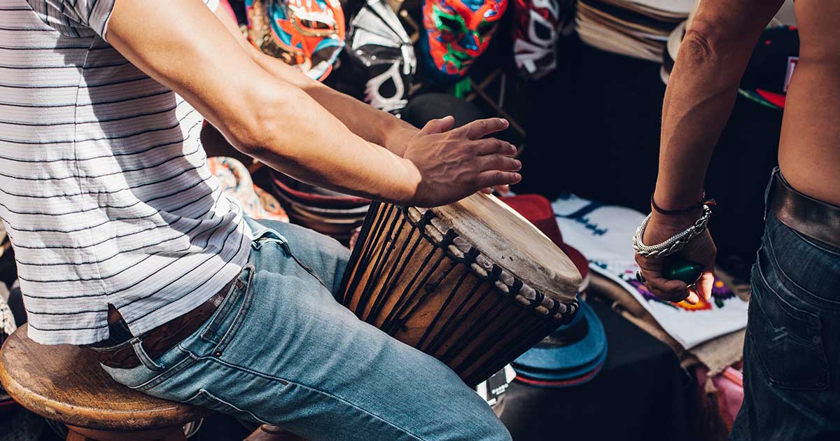 A person playing a hand drum.
