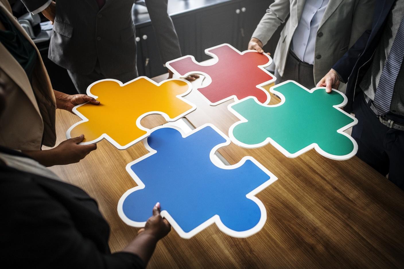 team brings puzzle pieces together to demonstrate how they collaborate on solutions to a problem