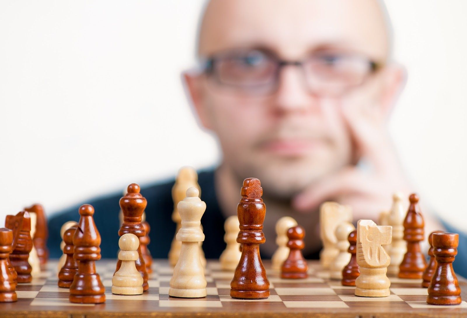 Man staring at chessboard considering next move