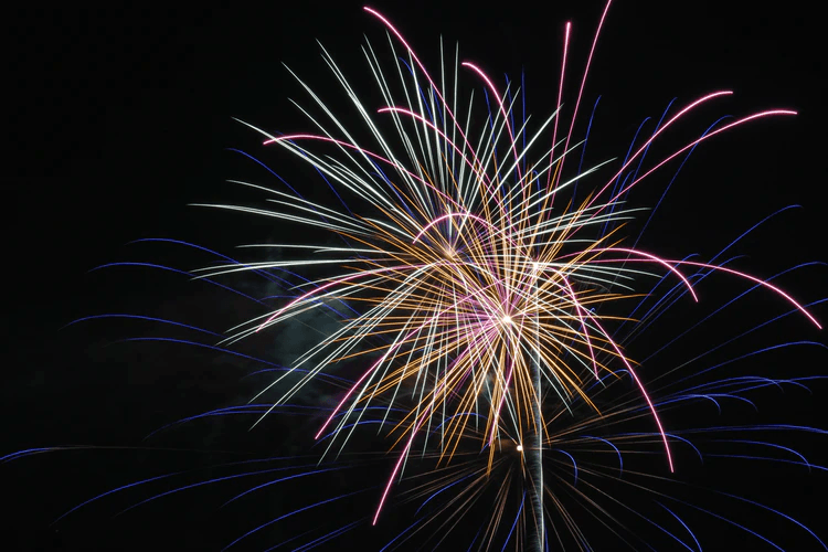 Red, green, and white fireworks in the sky.