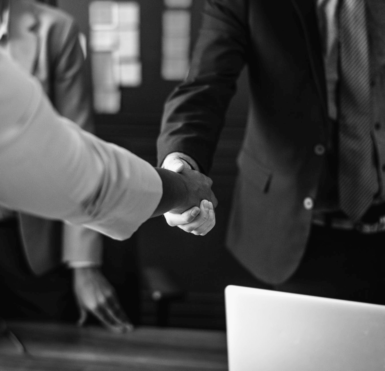 Black and white photo of two people shaking hands.