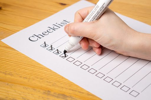 Black marker checking new hire onboarding checklist
