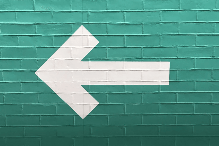An image of a green wall with a white arrow on it.