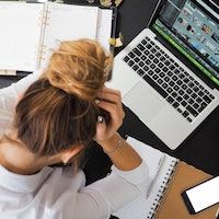 stressed woman with head in hands at computer