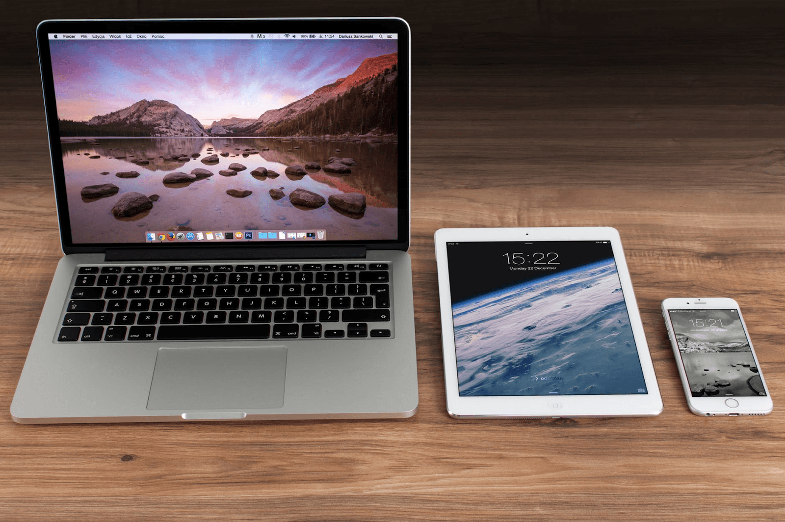 A Mac computer, Apple iPad, and iPhone sitting side by side.