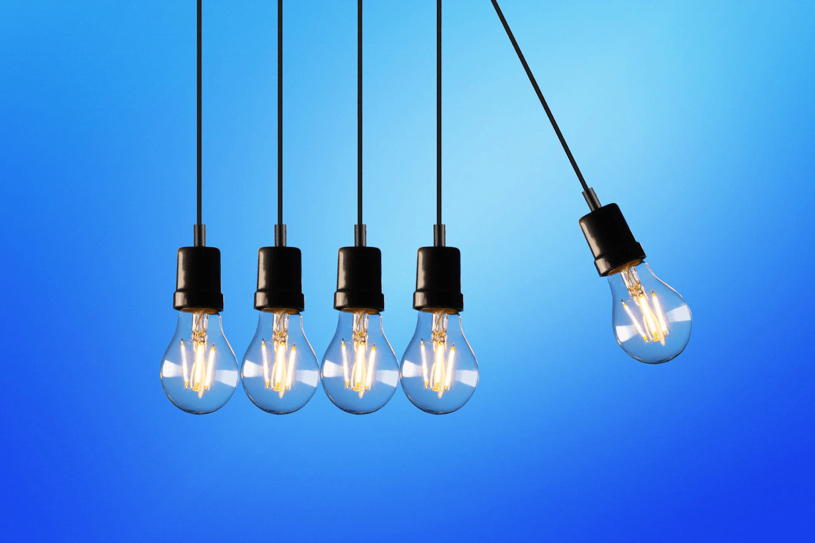 Five hanging light bulbs with a blue background.