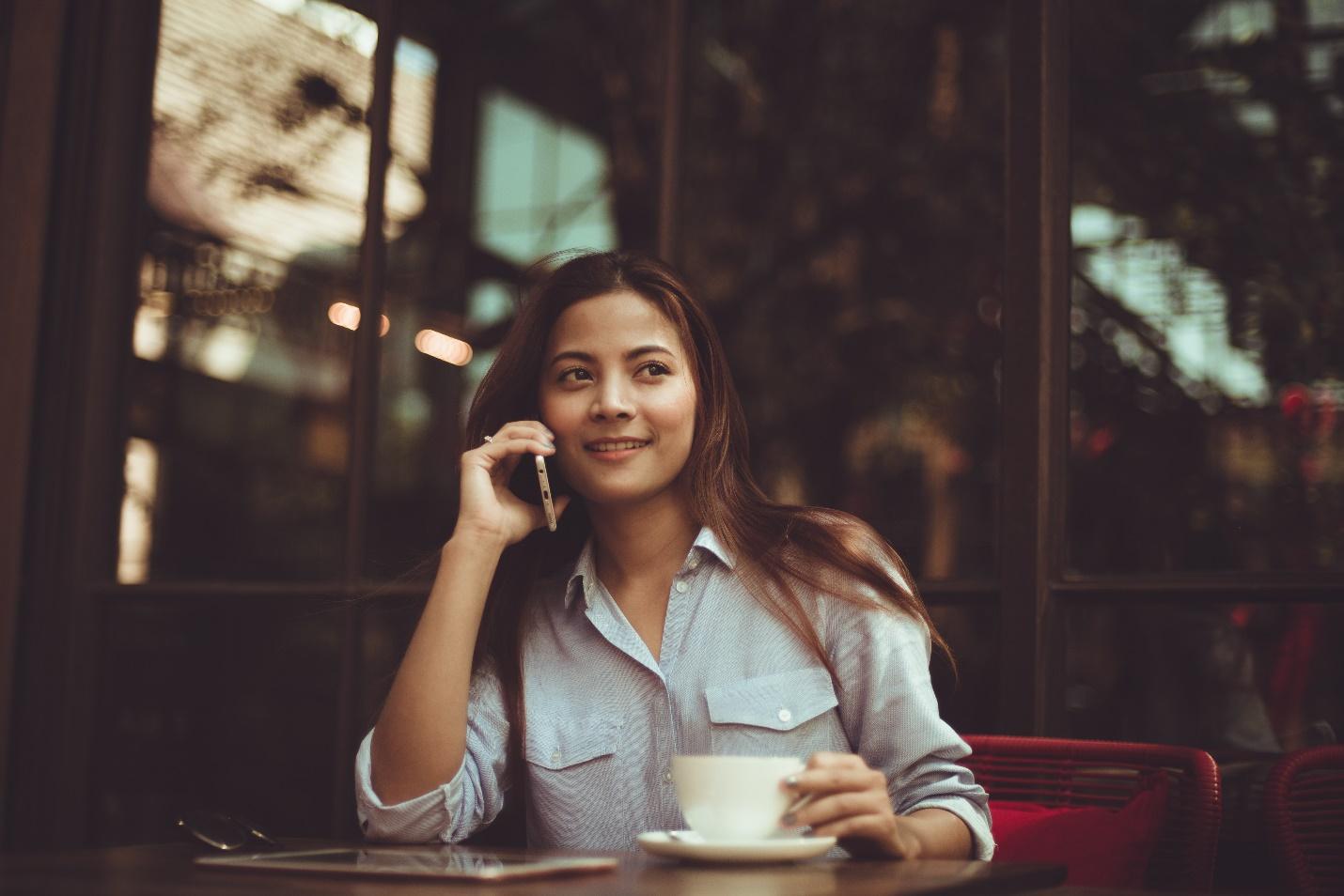 woman takes a business call at a cafe
