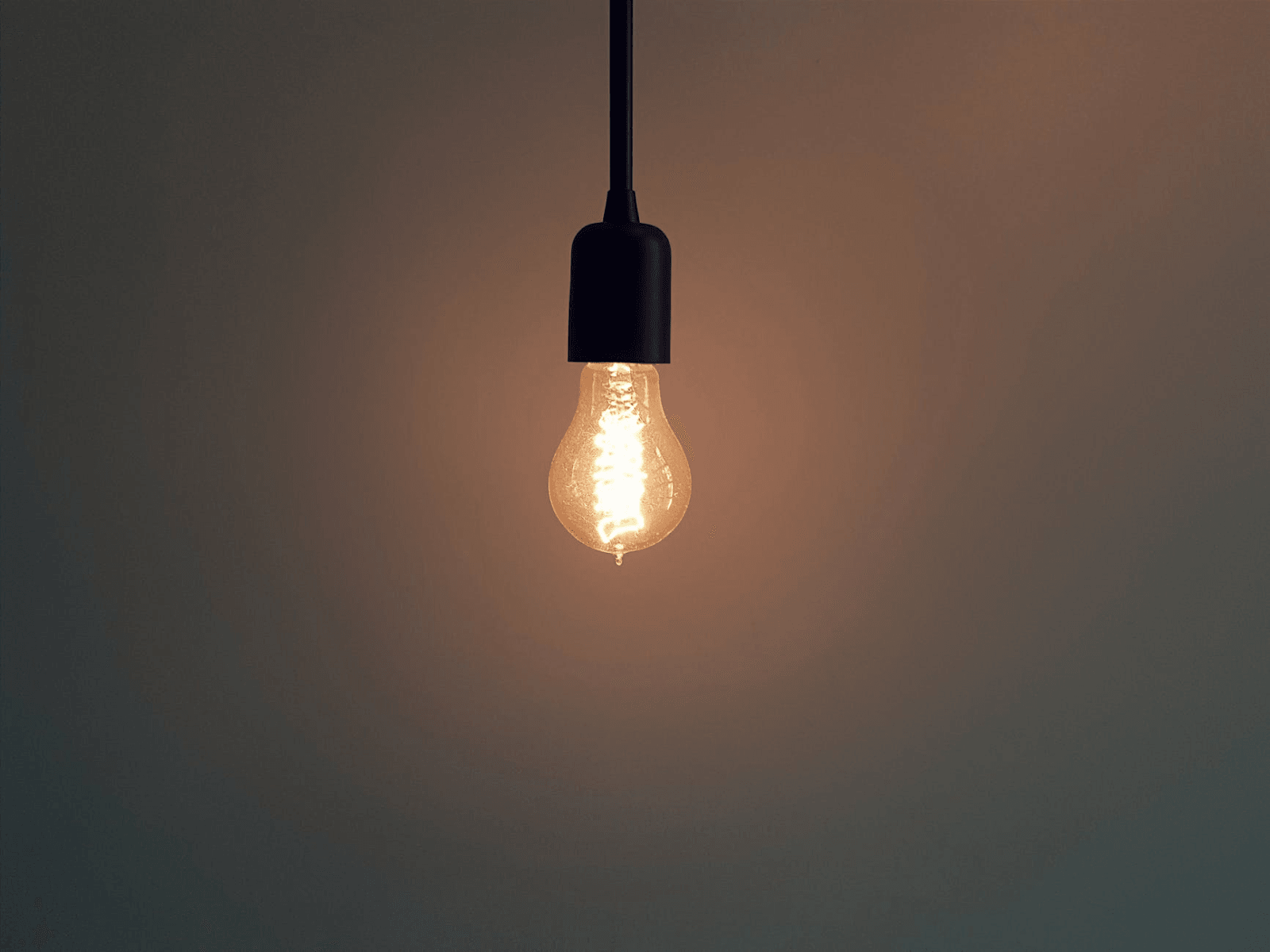 A single lit light bulb hanging from a cord.