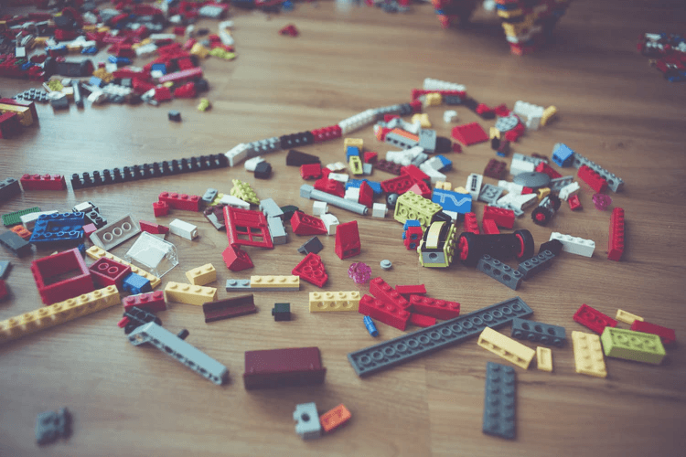 An assortment of Lego blocks on a wood floor.