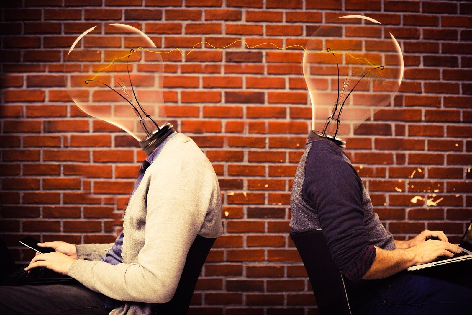 Men with lightbulb heads typing out product development plan