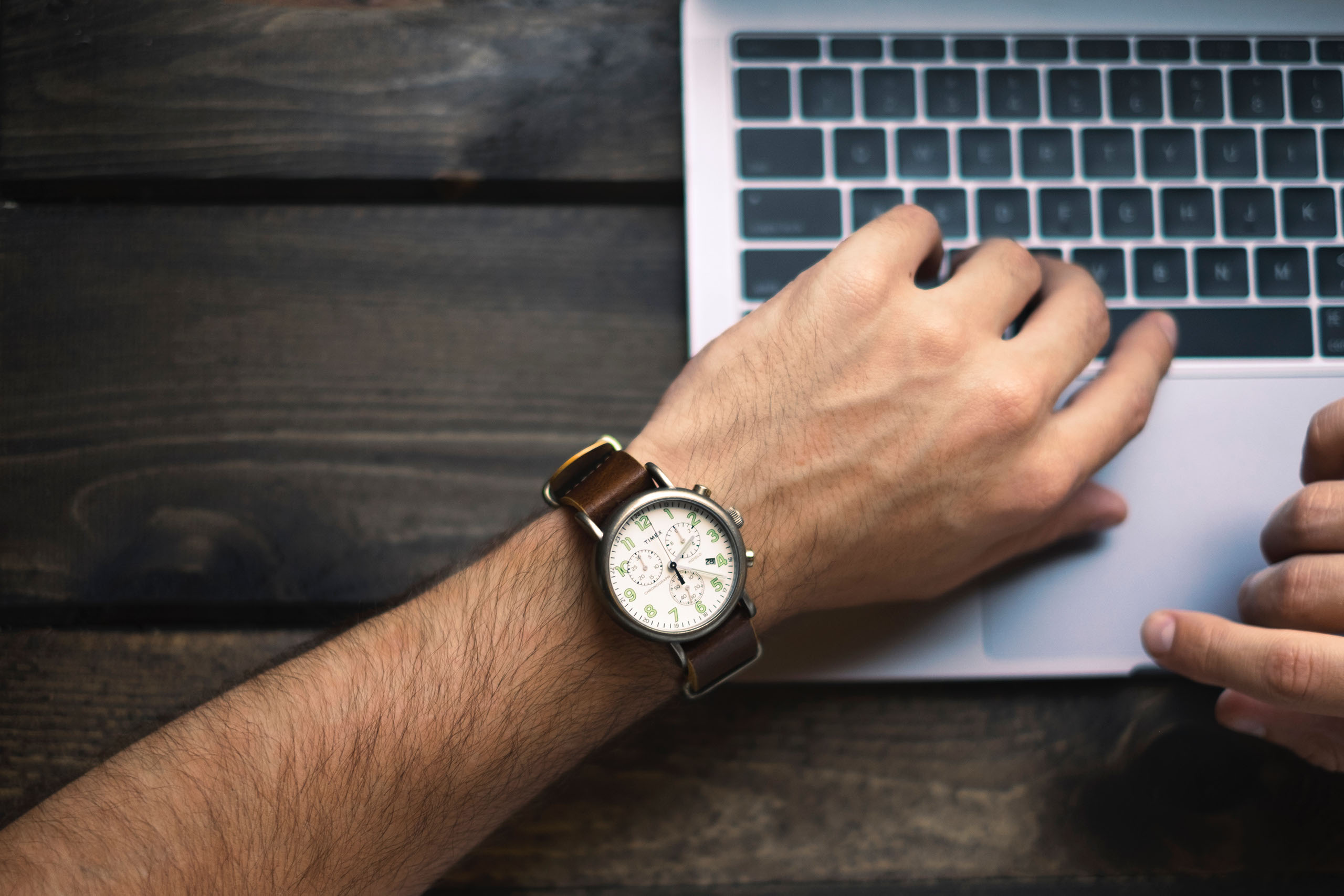 Man with watch on laptop