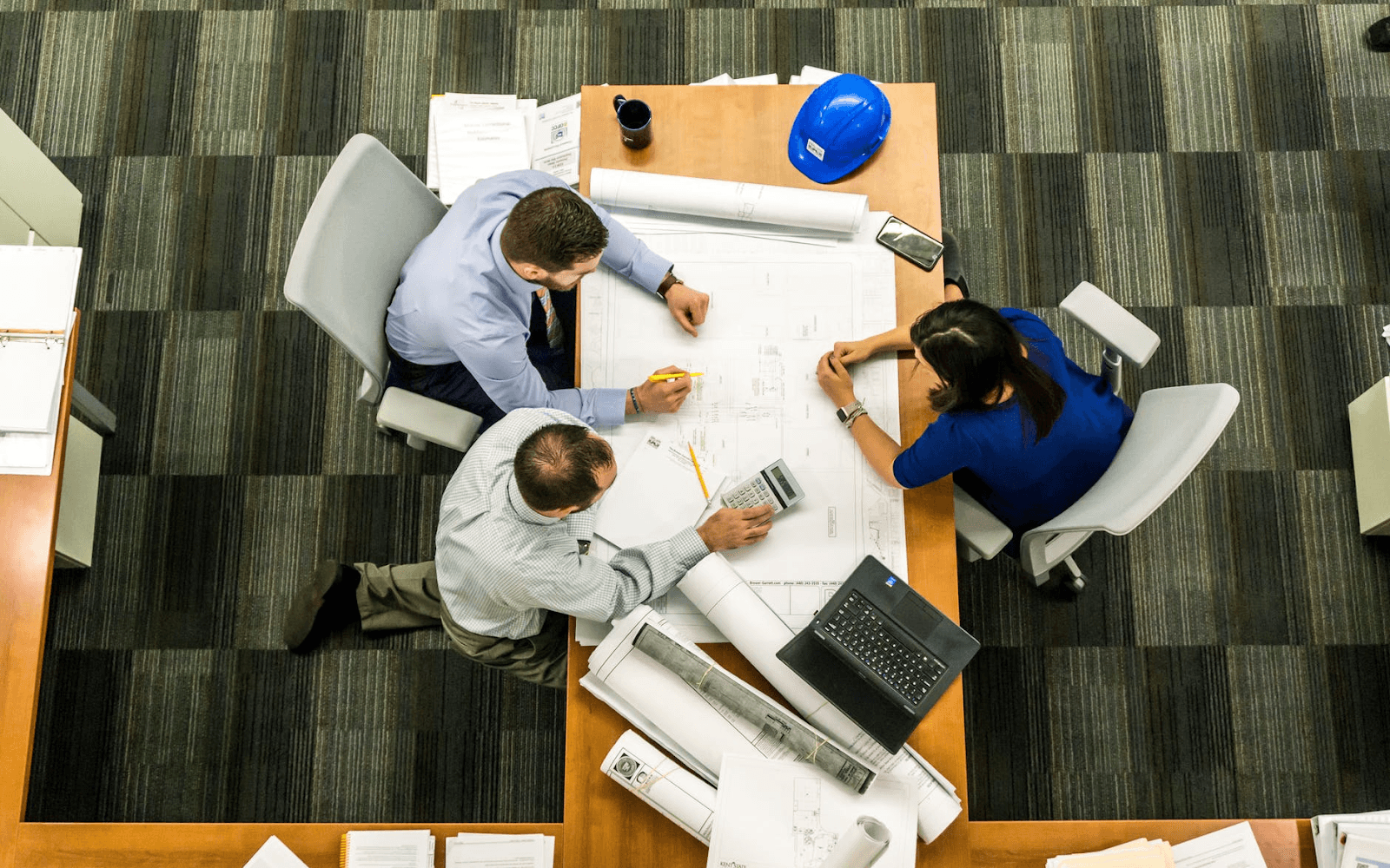 Three people gathered around a table.