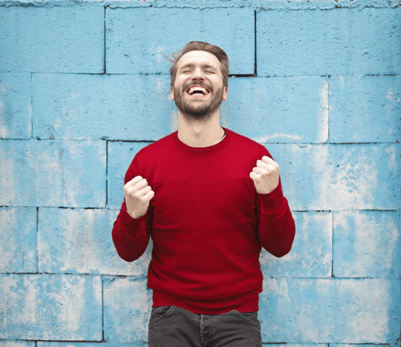 A man in a red shirt smiling.