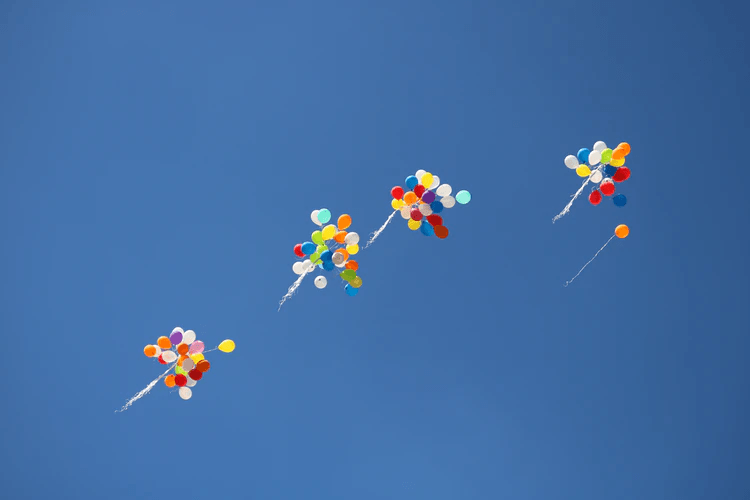 Balloons floating higher in the sky.