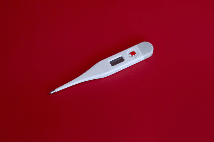 A thermometer set against a red background.