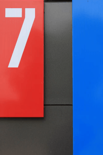 The number seven against a red, black, and blue background.