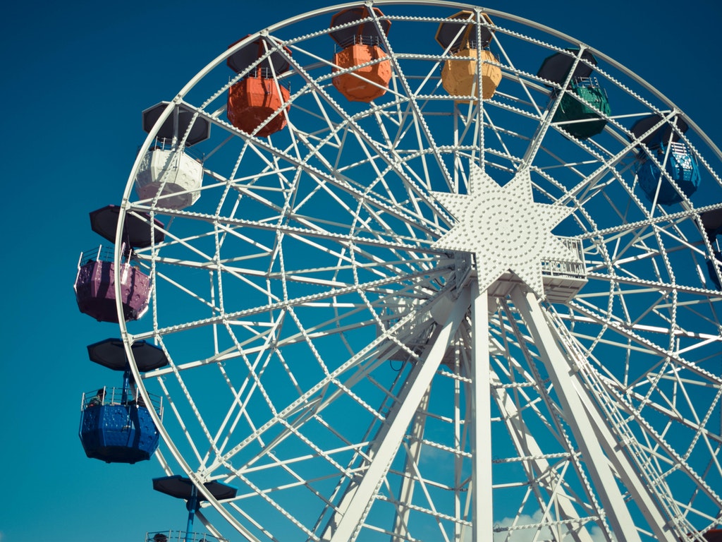 a white ferris wheel against a cloudless blue sky