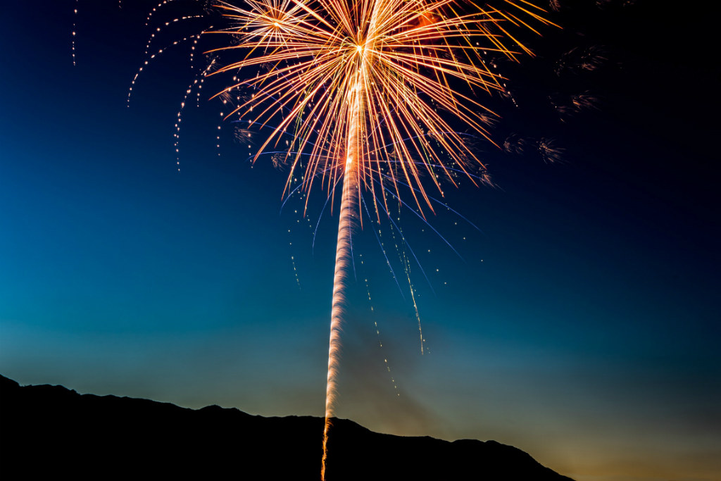 a firework lights up a dark blue sky