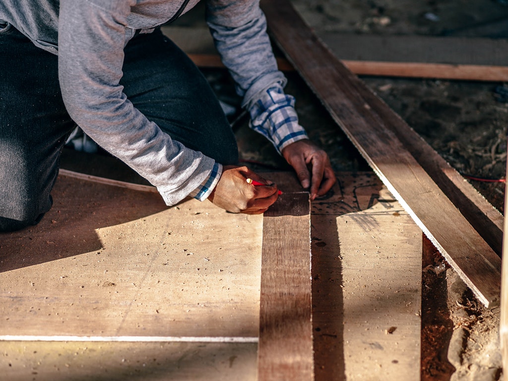 a person laying hardwood floor