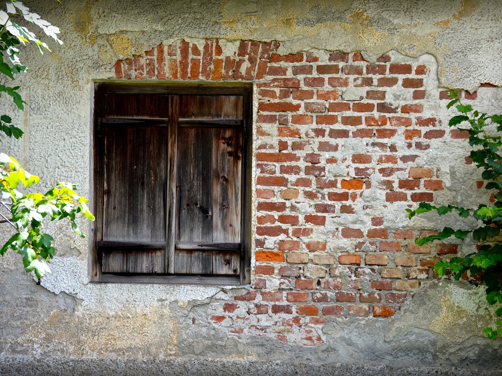 exterior wall with exposed brick and a wooden door