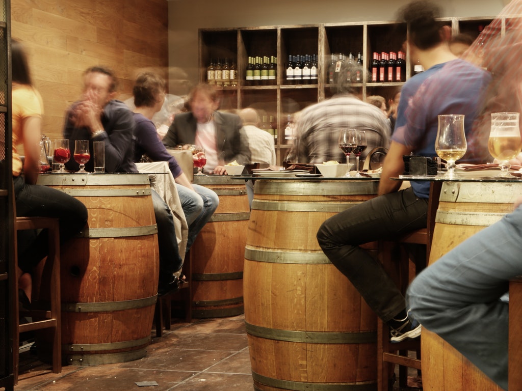 people sitting around barrels at a restaurant in ohio