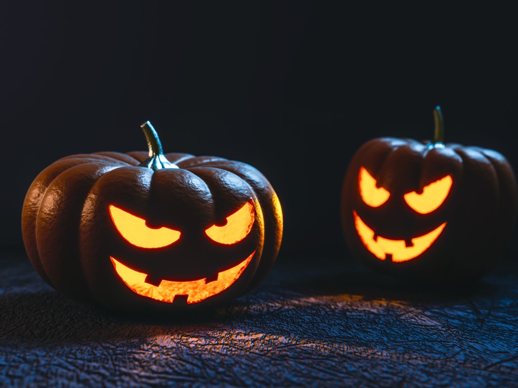 two jack o lanterns glowing at night