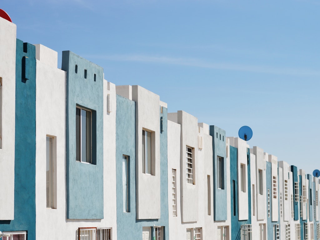 a series of identical blue and white suburban homes