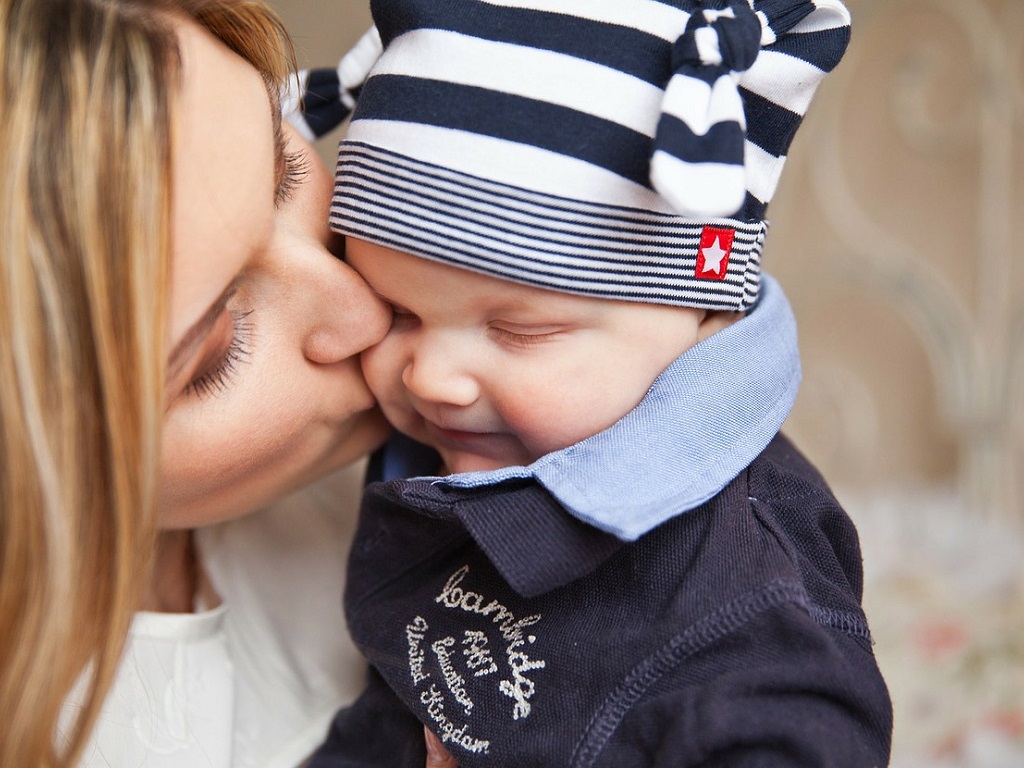 mom kissing a baby's cheek