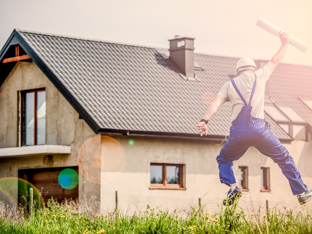 a person jumping for joy by a home