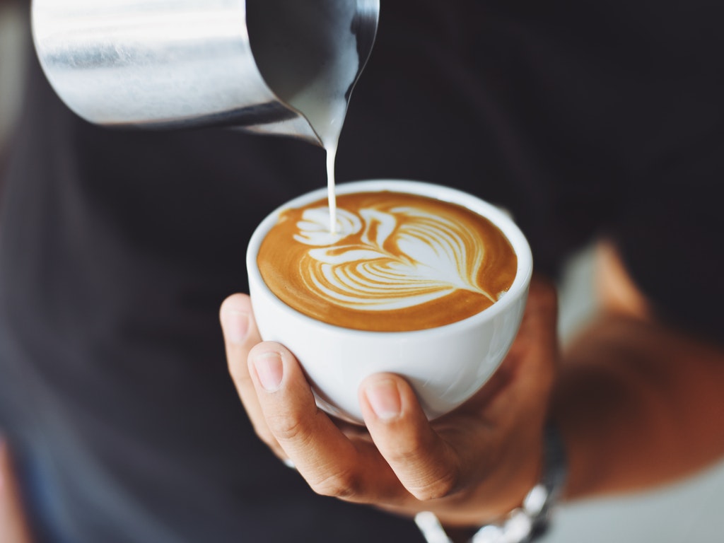 a barista finishes a latte