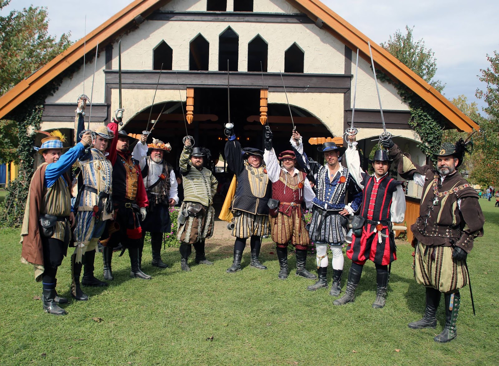 group of men in renaissance costumes holding up swords