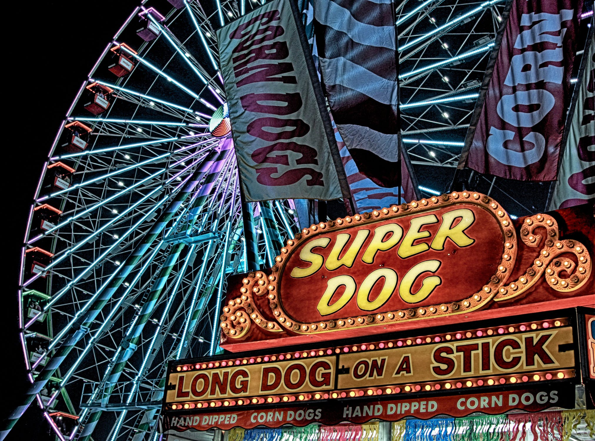 a corn dog stand in front of a ferris wheel