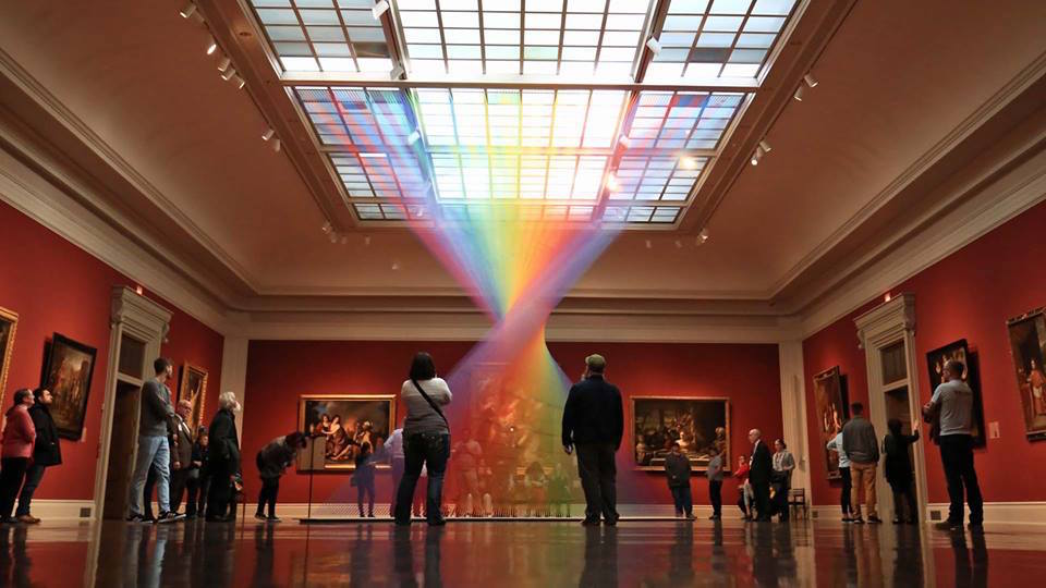 people looking at a rainbow display at the toledo museum of art