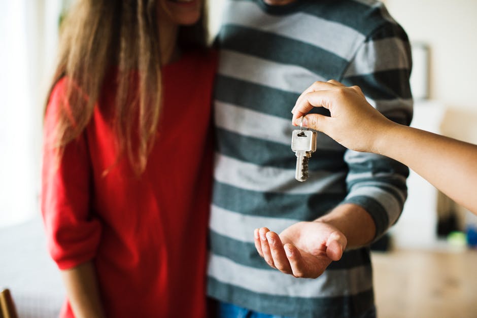 realtor handing couple a house key 