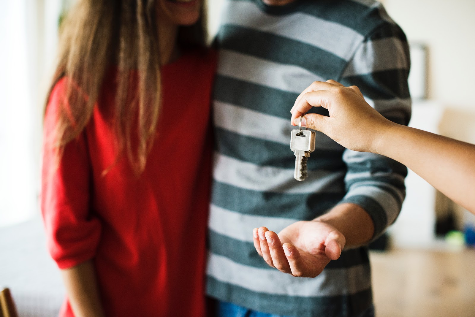 real estate agent handing over key to new home owners